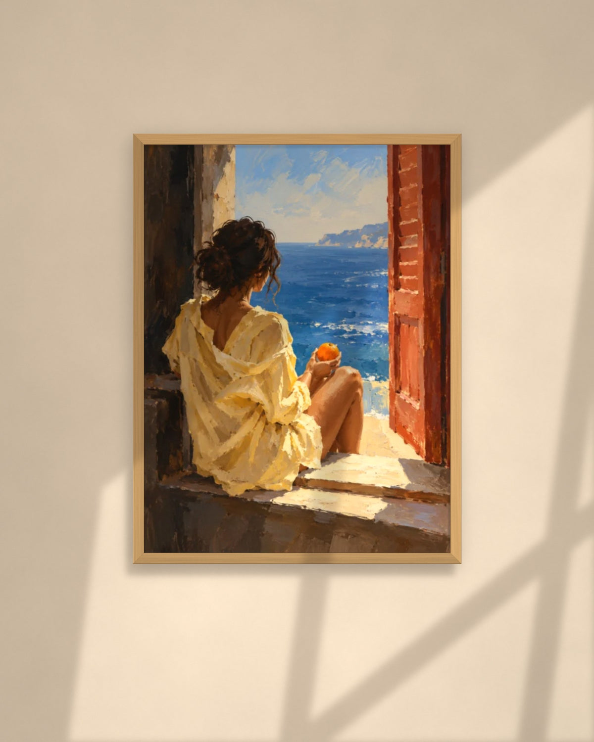Orange by the Sea art print in a natural oak frame above a cream sofa in a sunlit living room