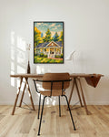 Summer Cottage art print in a black frame above a wooden desk in a bright Scandinavian study