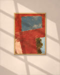Terracotta Window art print in a walnut frame above a brown leather Chesterfield armchair