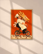The Baguette Run art print in a natural oak frame above a wooden desk in a bright Scandinavian study