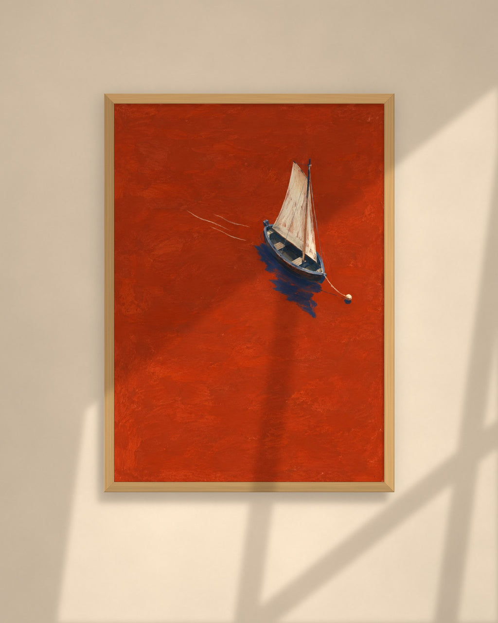 Vermilion Sail art print in a walnut frame above a brown leather Chesterfield armchair